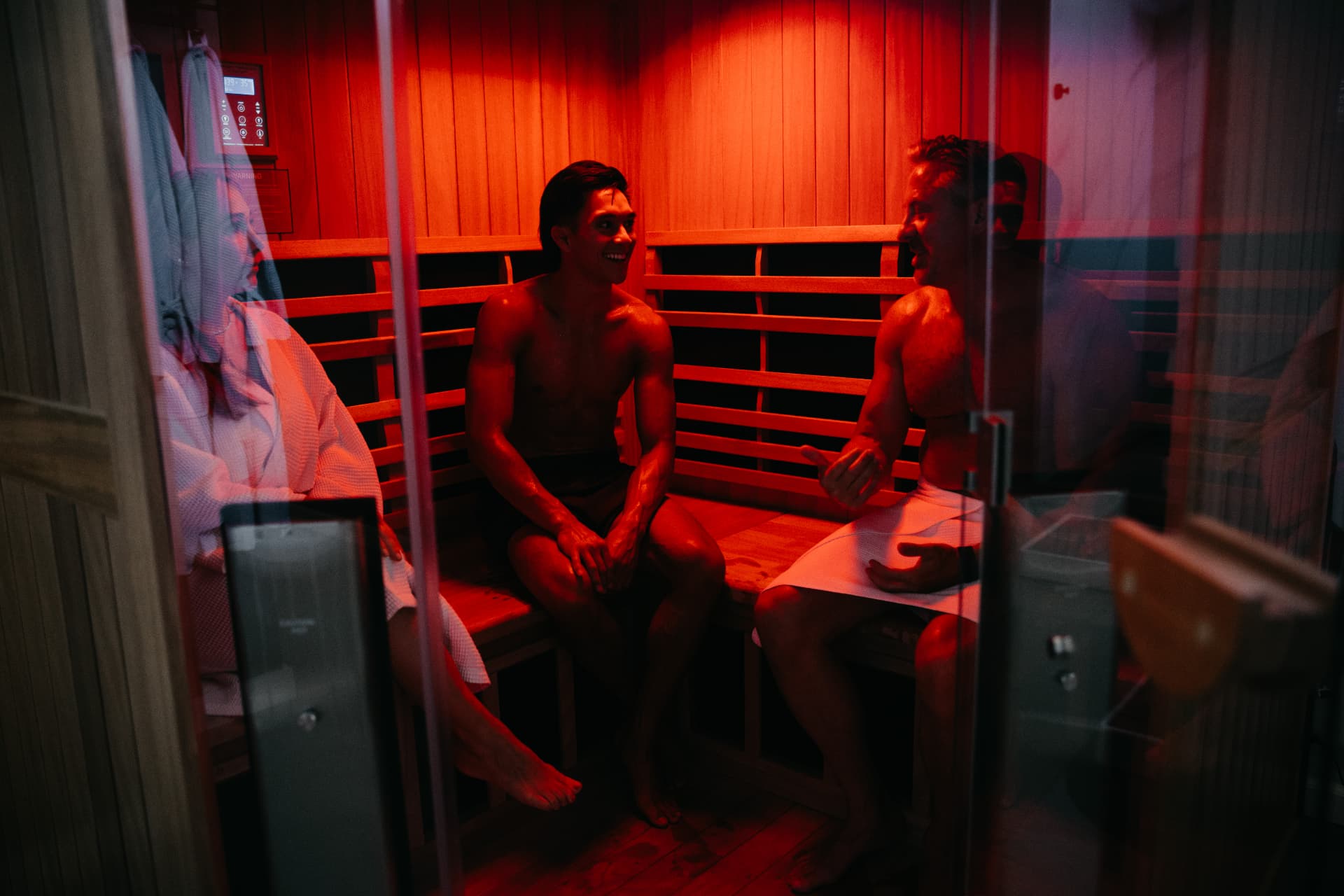 Two members talking inside the full spectrum infrared sauna at Recharge